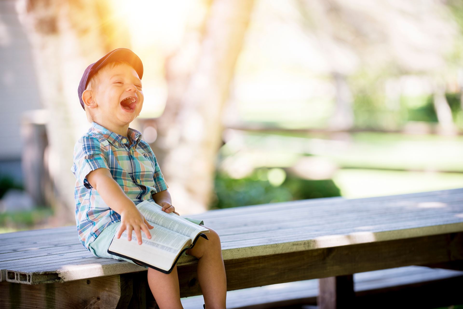 a little girl sitting on a wooden bench